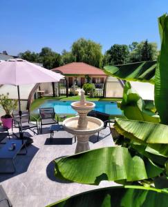 a patio with a fountain next to a pool at Logis Hôtel & Spa Le Saint Antoine in Lamarche-sur-Saône