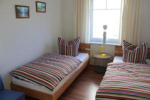 two beds in a room with a window at Haus Schwalbennest in Dassow