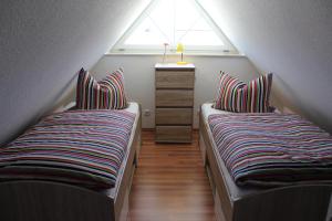 two beds in a attic room with a window at Haus Schwalbennest in Dassow
