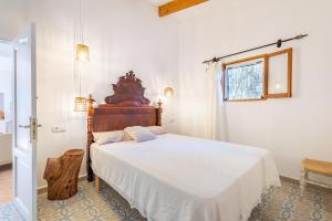 um quarto com uma cama grande e uma cabeceira em madeira em Marina Ses Covetes em Campos