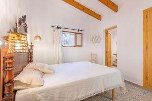 ein Schlafzimmer mit einem Bett mit weißen Laken und einem Fenster in der Unterkunft Marina Ses Covetes in Campos