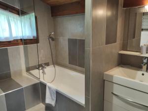 een badkamer met een douche, een bad en een wastafel bij Appartement Les Gets, 2 pièces, 5 personnes - FR-1-671-15 in Les Gets