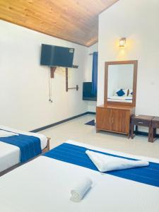 Pokój hotelowy z 2 łóżkami i lustrem w obiekcie Yatinuwara Bungalow w mieście Anuradhapura