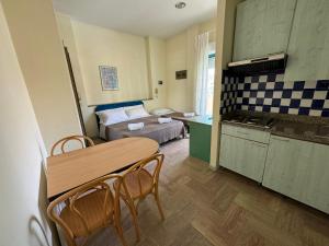 a kitchen with a table and a bed in a room at Bellariva appartamenti in Rimini