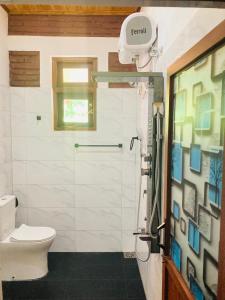 a bathroom with a shower with a toilet and a window at Yatinuwara Bungalow in Anuradhapura