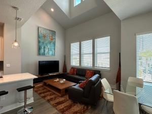 a living room with a couch and a tv at Luxurious Three-story Townhouse In Payne Park Village in Sarasota