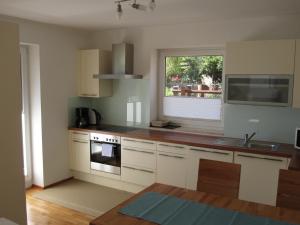 a kitchen with white cabinets and a sink and a window at Ferienwohnung Bergpanorama in Fulpmes