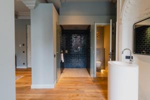 a bathroom with a glass shower and a toilet at Hotel Monastère Maastricht in Maastricht