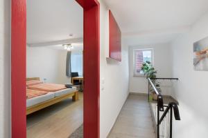 eine rote Tür, die zu einem Schlafzimmer mit einem Bett führt in der Unterkunft Ferienhaus Doris in Bad Urach
