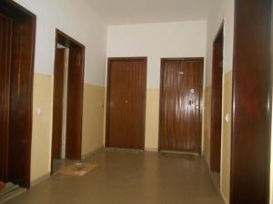 an empty room with three wooden doors in it at Condominio Lido in Porto Garibaldi