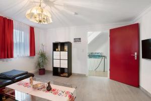 Sala de estar con puerta roja y mesa en Ferienhaus Doris, en Bad Urach