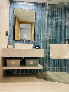 een badkamer met een wastafel en een spiegel bij Flamingo Ibiza Hải Tiến in Thanh Hóa
