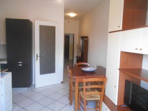 cocina con mesa, sillas y puerta en Condominio Lido, en Porto Garibaldi