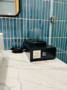 a black appliance sitting on a counter in a bathroom at Flamingo Ibiza Hải Tiến in Thanh Hóa