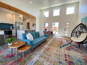 ein Wohnzimmer mit einem blauen Sofa und einer Küche in der Unterkunft Timber & Tin E 2Bed 2Bath w Pool & Rooftop Deck in Kanab