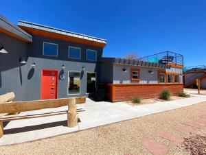 a house with a red door and a fence at Timber & Tin G 2Bed 2Bath w Pool & Rooftop Deck in Kanab