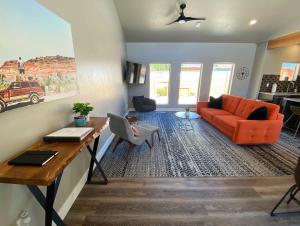 a living room with an orange couch and a table at Timber & Tin G 2Bed 2Bath w Pool & Rooftop Deck in Kanab