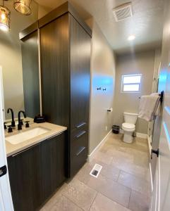 a bathroom with a sink and a toilet at Timber & Tin G 2Bed 2Bath w Pool & Rooftop Deck in Kanab