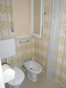y baño con aseo y lavamanos. en Condominio Lido, en Porto Garibaldi