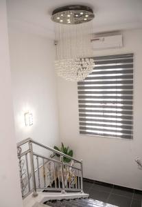 a chandelier in a white room with a staircase at Duplex16 in Enugu