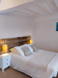a bedroom with a white bed with a wooden headboard at Magnolias in Chinon