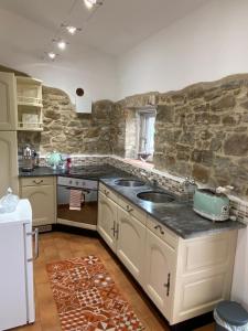 cocina con fregadero y pared de piedra en Tenuta Le Mandorlaie, Agriturismo in Scansano, en Scansano