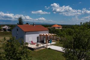 uma pequena casa branca com um telhado vermelho em Holiday House Beram em Zadar