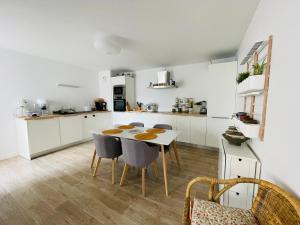 een keuken en eetkamer met een tafel en stoelen bij Appartement 2 chambres Lille - proche du métro in Lille