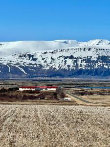 uma montanha coberta de neve com um comboio à sua frente em Vökuholt Lodge em Laxamýri