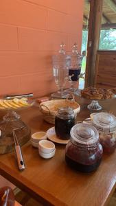 uma mesa com vários tipos diferentes de alimentos em Hospedagem Cabanas do Lago Urubici em Urubici