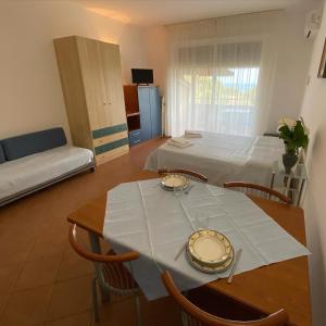 a living room with a table and a bed at Jonio Vacanze Residence in Castellaneta Marina