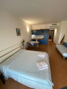 a bedroom with a large bed and a kitchen at Jonio Vacanze Residence in Castellaneta Marina 