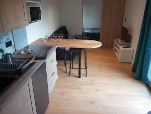 a kitchen with a wooden table in a room at Maisonnette au calme in Marlens