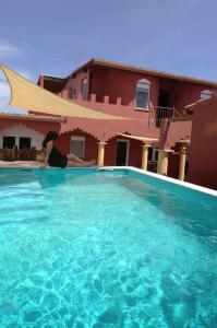 une femme qui se couche dans une piscine à côté d'une maison dans l'établissement Aladin Comfort Country House, à Campinho