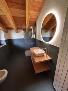 ein Bad mit einem Waschbecken und einem Spiegel in der Unterkunft Chalet 181 Grand Haury in Arvier