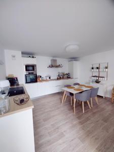 een keuken en een woonkamer met een tafel en stoelen bij Appartement 2 chambres Lille - proche du métro in Lille