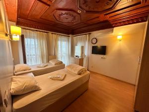 a bedroom with two beds and a ceiling with a tv at Adil Konak Hotel in Istanbul
