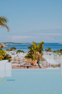 a swimming pool with a view of the ocean at Nativo Hotel Ibiza in Santa Eularia des Riu