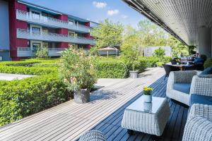 eine Terrasse mit Stühlen und Tischen sowie ein Gebäude in der Unterkunft Senevita Residenz & Apartments Muri bei Bern in Bern