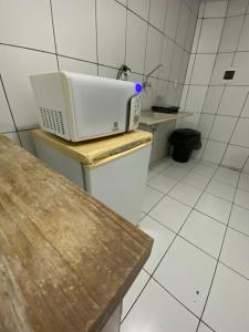 a kitchen with a microwave sitting on top of a toilet at Hoje Apartamentos in Feira de Santana