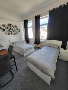 - une chambre avec deux lits, un bureau et une chaise dans l'établissement Ferienzimmer in Euskirchen, à Euskirchen