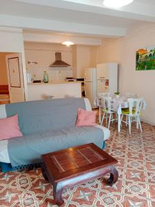 - un salon avec un canapé bleu et une table dans l'établissement T3-HELTYMIE-terrasse-4 pers-idéal famille-parking gratuit-5 min des plages, à Portiragnes