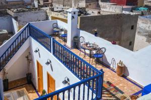 a balcony with tables and chairs on a building at Riad Babette in Essaouira