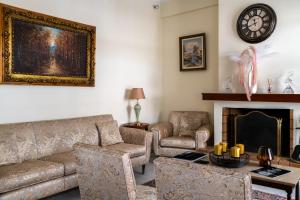 sala de estar con sofá, sillas y chimenea en Analiti Civita - Mando en Patras