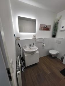 La salle de bains blanche est pourvue d'un lavabo et de toilettes. dans l'établissement Ferienzimmer in Euskirchen, à Euskirchen