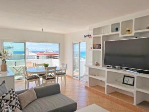 sala de estar con TV de pantalla plana grande en Algarve Sol Beach House, en Quarteira
