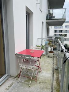 een rode tafel en een stoel op een balkon bij Appartement 2 chambres Lille - proche du métro in Lille