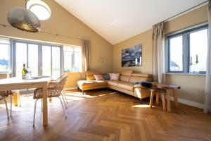 ein Wohnzimmer mit einem Sofa und einem Tisch in der Unterkunft Haus Lillemor Wohnung 2 in Wyk auf Föhr