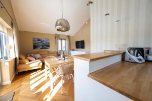 eine Küche und ein Wohnzimmer mit einem Tisch in der Unterkunft Haus Lillemor Wohnung 2 in Wyk auf Föhr