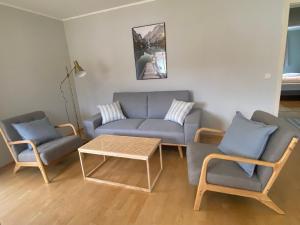 uma sala de estar com um sofá, cadeiras e uma mesa em Modern eingerichtete Wohnung mit 2 Schlafzimmern em Bergen